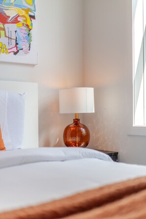A hotel room with a bed, a lamp, and a painting on the wall. - Stunning 3BR in Plateau Mont-Royal (Montréal)