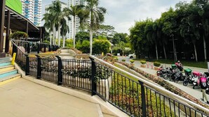 A modern urban area with a pedestrian walkway, a green-roofed building, and several high-rise buildings in the background. -  A spacious 31sqm studio unit in abreeza place (Davao City)