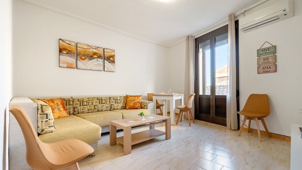 A living room with a sofa, a coffee table, a chair, and a dining table. - Apartment 'El Compromiso' with Balcony, Wi-Fi and Air Conditioning (Caspe)