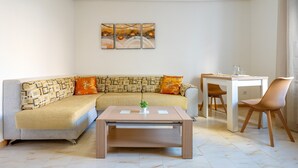 A living room with a sofa, coffee table, and dining table. - Apartment 'El Compromiso' with Balcony, Wi-Fi and Air Conditioning (Caspe)