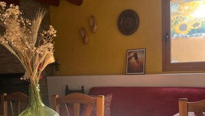A dining table with a floral placemat, a vase with dried flowers, and a wooden ceiling. - Country House 'Fe' with Private Terrace, Private Garden and Balcony (Capdesaso)