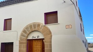 A building with a stone archway entrance labeled 'Casa Te,' a wooden door, and a small window with a shutter. - Country House 'Fe' with Private Terrace, Private Garden and Balcony (Capdesaso)