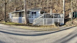 A cabin with a porch, a staircase, and a view of the surrounding forest. - Charming 1-Bedroom, 1-bunk room, fishing in Gate City with Central Air, WiFi (Gate City)