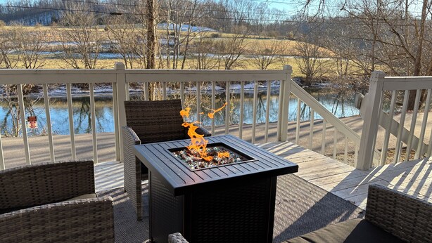 A deck with a fire feature, wicker furniture, and a view of a body of water. - Charming 1-Bedroom, 1-bunk room, fishing in Gate City with Central Air, WiFi (Gate City)