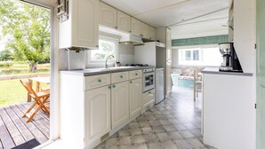 A compact kitchen with white cabinets, a built-in oven, and a coffee maker. - Mobile Home for 3 People at Lake Isachris – Hiking and Relaxation in the Médoc (Queyrac)