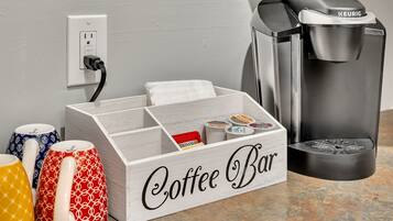 Una preparación para cafetería con una cafetera Keurig, un portavasos para tazas y una taza de café.