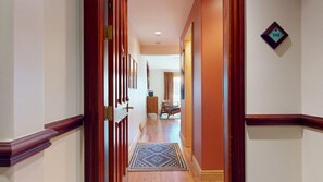 A hallway with wooden trim, a rug, and a door with a brass handle. - Luxury Studio | In Town | Wi-Fi | The Grande 312 (Angel Fire)