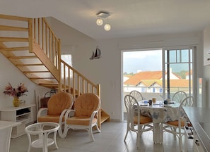 Un espace repas comprenant une table, des chaises et un escalier.