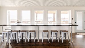 A kitchen with a long island counter and six stools. - 1 Block from the Beach, Entertainment Deck with games and Tv, large enough for 26 guests. (Bolivar Peninsula)