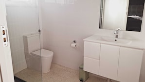Un baño pequeño y funcional con inodoro, lavamanos y espejo.