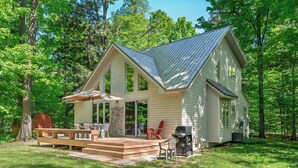 A two-story house with a porch, a deck, and a grill area. - Up North Chalet | Ac | Bbq | Bikes (Cedar)