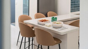 A modern kitchen with a central island, four chairs, and a dining table. - Gapyeong Dream Pool Villa Pension (Gapyeong)