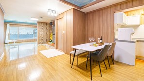 Enjoy meals in this dining area with a view of the outdoors, featuring a table for two and a refrigerator.