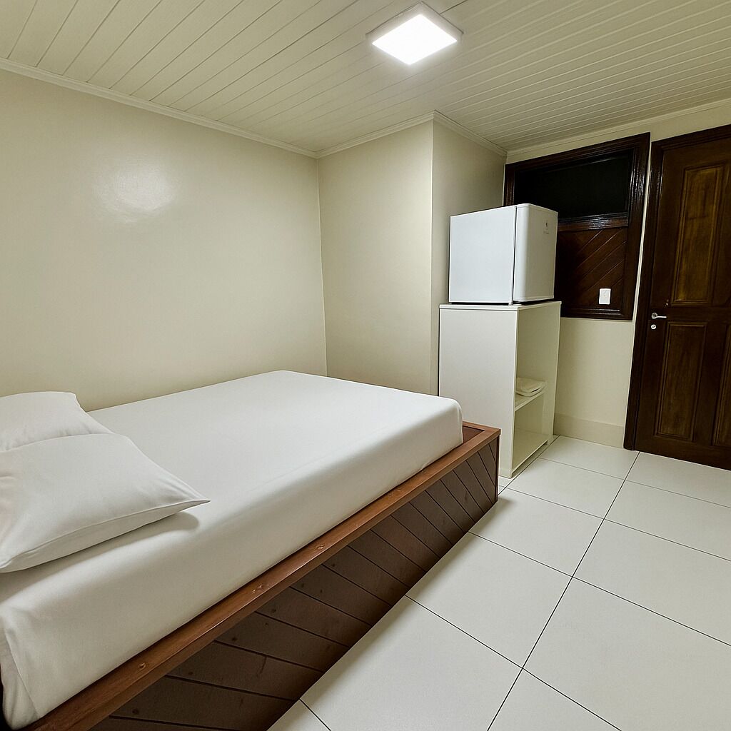Un dormitorio con una cama, un armario blanco y una puerta.