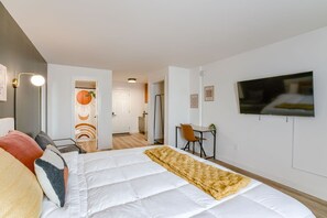 Une chambre moderne avec un grand lit, un bureau et un téléviseur.