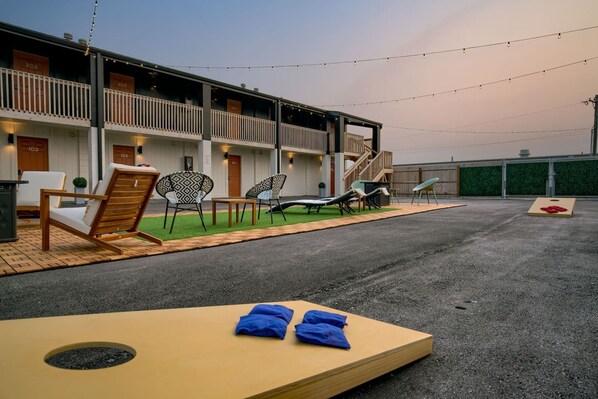 Un hôtel doté d’un espace extérieur aménagé, comprenant des chaises longues et une table avec des serviettes.