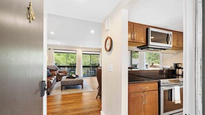 A modern kitchen with wooden cabinets, a stainless steel oven, and a microwave. - Lakefront Pinehurst Condo 2BD/2BA - 237 - With Community Pool Access (Pinehurst)