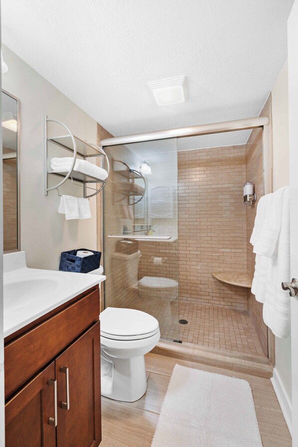 A modern bathroom with a shower, toilet, and vanity. - Lakefront Pinehurst Condo 2BD/2BA - 237 - With Community Pool Access (Pinehurst)