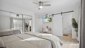 Une chambre moderne avec un grand lit, un bureau et une télévision.