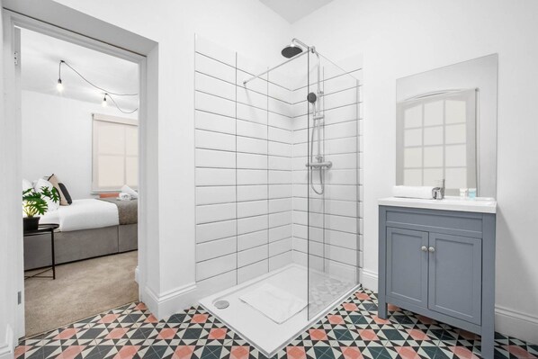 Ein modernes Badezimmer mit Dusche, Waschbecken und Spiegel.