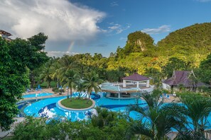 A resort with a large swimming pool, palm trees, and a view of a mountain. - Krabi Maritime Resort  (Krabi)
