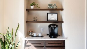 A kitchen counter with a coffee maker, two mugs, a framed WiFi sign, and a potted plant. - Spacious 4BR Home+Patio Retreat (Centennial)