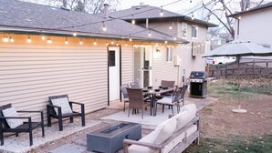 A backyard patio with outdoor furniture, a fire pit, and string lights. - Spacious 4BR Home+Patio Retreat (Centennial)