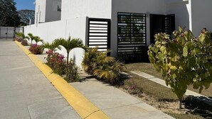 Un bâtiment moderne à deux étages, doté d’un toit plat, de grandes fenêtres et d’une entrée sécurisée par un portail.