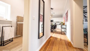 A modern kitchen with wooden flooring, a dining area with chairs, and a large mirror on the wall. - 6 rooms 5 bedrooms 2 bathrooms- close to the city center top renovated (Brunsbüttel)