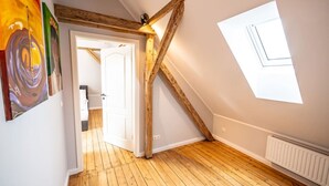 A room with wooden beams, a sloped ceiling, and a door leading to another room. - 6 rooms 5 bedrooms 2 bathrooms- close to the city center top renovated (Brunsbüttel)