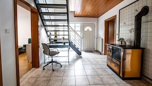 A modern kitchen with a built-in stove, a staircase leading to another room, and a dining area with a table and chairs. - Beautiful house with conservatory and garden and large bathrooms (Brunsbüttel)