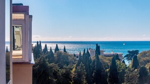 Une vue sur la côte, avec un ciel dégagé, une étendue d’eau et un bâtiment doté d’un balcon.