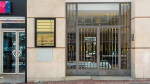 Une entrée d’immeuble avec une enseigne indiquant « EDF. ACADEPULCO » et un portail de sécurité.