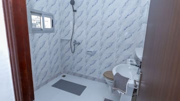 Een douche, handdoeken, zeep, toiletpapier