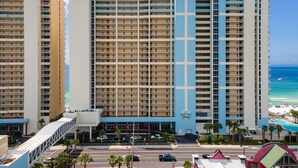 Ein Hochhaus-Hotel mit mehreren Balkonen, einem Pool und Blick auf den Strand.