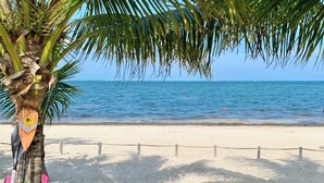 Une plage avec un palmier et un kayak.