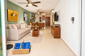 A modern living room with a sofa, coffee table, and a dining area with chairs and a table.