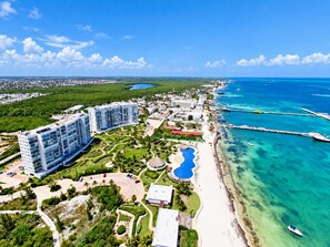 Un resort con varios edificios de gran altura, una playa y un mar azul cristalino.
