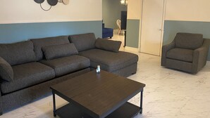 A living room with a sectional sofa, a coffee table, and a chair. - Spacious 5-bedroom house in fabulous Hot Springs 1.2 miles from Oaklawn Park (Hot Springs)