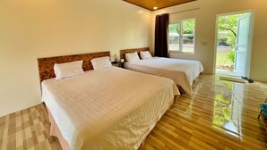 Una habitación de hotel con dos camas, techo de madera y vistas al exterior.