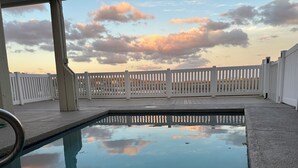 Piscina com cerca branca ao fundo.