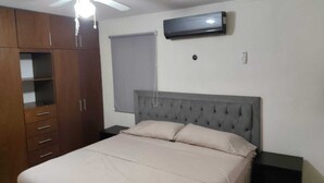 A bedroom with a bed, a wardrobe, a ceiling fan, an air conditioning unit, and a window with a blind. - Comfortable & Beautiful house in Caucel (Merida)