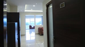 A hotel room with a large window, a door with a number, and a view of the outside. - Hotel Veera (Mukerian)