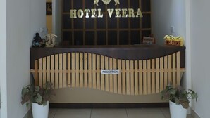 A reception desk with a sign reading "HOTEL VEERA" and a "RECEPTION" sign below it. - Hotel Veera (Mukerian)