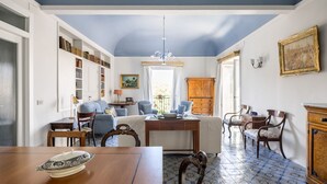 A room with a bed, a desk, a chair, a bookshelf, and a dining table. - Palazzo Fatta Apartment by DomuSicily (Palermo)