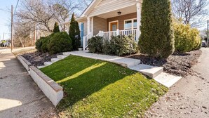 Une maison de plain-pied avec un porche à l’avant, une pelouse bien entretenue et une allée.