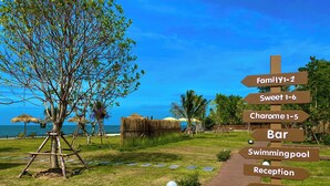 A signpost with directions to various amenities including Family 1-2, Sweet 1-6, Charme 1-5, Bar, Swimming Pool, Reception, Lounge, and Cafe. - Charome Resort (Khlong Yai)