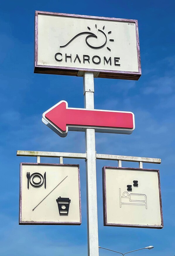 A sign with the word "CHAROME" and a red arrow pointing left. Below are symbols for a bed, a trash can, and a fork and knife. - Charome Resort (Khlong Yai)