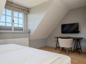 Ein Schlafzimmer mit einem Bett, einem Schreibtisch und einem Fernseher.