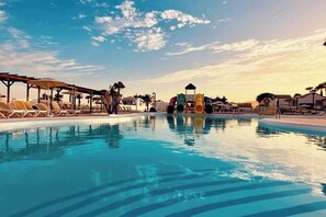 A swimming pool with lounge chairs and a water slide. - Caleta de Fuste Apartment- Sleeps4- Pool- Garden (Caleta de fuste)
